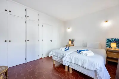 a bedroom with white cabinets and a bed at Casa Jóia in Luz