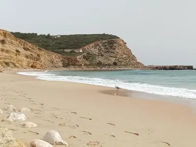 a kitchen with white cabinets and a sink and a refrigerator at Casa Raios de Sol in Burgau