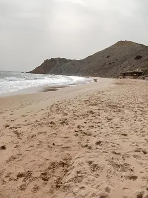 a beach with rocks on the sand and the ocean at Casa Raios de Sol in Burgau