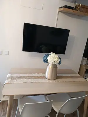 a dining room table with a vase of flowers on it at Casa Raios de Sol in Burgau