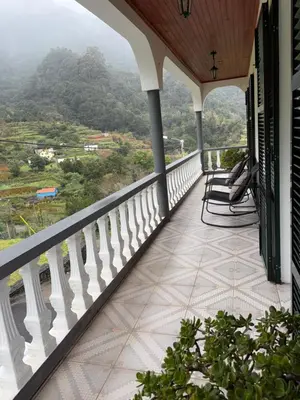 a balcony with chairs and a view of a mountain at Mountain retreat in Boaventura