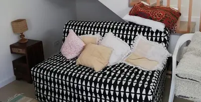 a black and white couch with pillows on it at Estudio Hortas in Vila do Bispo