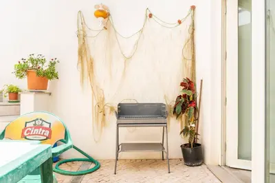 a room with a table and a grill on a wall at Estudio Hortas in Vila do Bispo