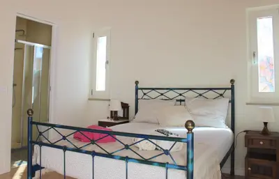 a bedroom with a bed with a blue frame at Estudio Hortas in Vila do Bispo