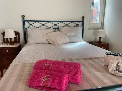 a bedroom with a large bed with pink towels on it at Estudio Hortas in Vila do Bispo