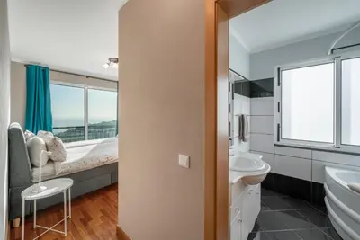 a bathroom with a bed and a sink at OurMadeira - Vista Mar in Canhas