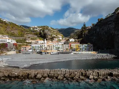 a town on a hill with a beach and buildings at OurMadeira - Vista Mar in Canhas
