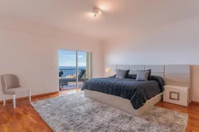 a bedroom with a bed and a view of the ocean at Sunspot Reis Magos with sea view by Holiday Rental Madeira in Caniço