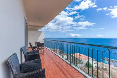 a balcony with chairs and a view of the ocean at Sunspot Reis Magos with sea view by Holiday Rental Madeira in Caniço