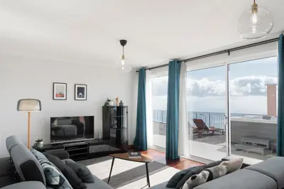 a living room with a couch and a television at Casa da Quinta Grande by An Island Apart in Câmara de Lobos
