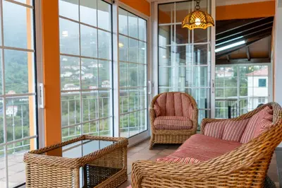 a room with two chairs and a couch on a balcony at The Mountain View, By OP in São Vicente
