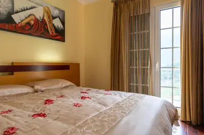 a bedroom with a bed with red flowers on it at The Mountain View, By OP in São Vicente