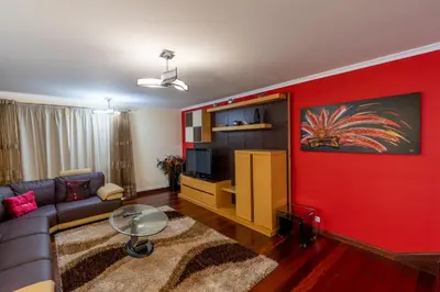 a living room with a couch and a red wall at The Mountain View, By OP in São Vicente