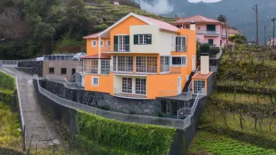 an orange and white house on top of a hill at The Mountain View, By OP in São Vicente