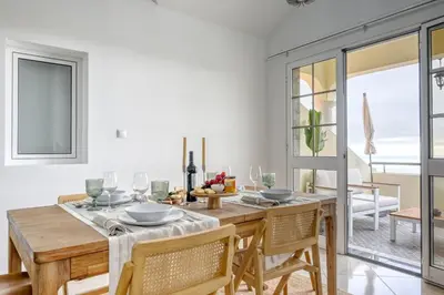 a dining room with a wooden table and chairs at Pôr do Sol, a Home in Madeira in Ponta do Sol
