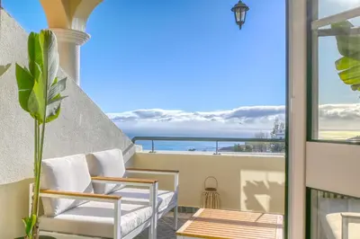 a balcony with chairs and a view of the ocean at Pôr do Sol, a Home in Madeira in Ponta do Sol