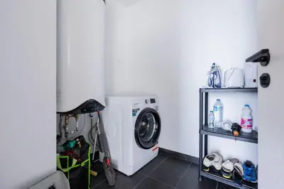 a laundry room with a washing machine and a shelf at The Place View in Funchal