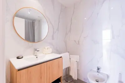 a white bathroom with a sink and a mirror at The Place View in Funchal