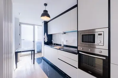 a kitchen with white cabinets and a microwave at The Place View in Funchal