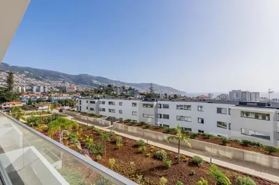 an apartment building with a garden on the roof at The Place View in Funchal