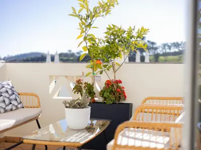 a balcony with two chairs and a table with plants at Dream Retreat in Budens #1948 in Budens