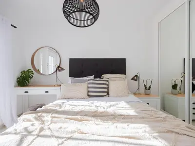 a white bedroom with a large bed with a mirror at Dream Retreat in Budens #1948 in Budens