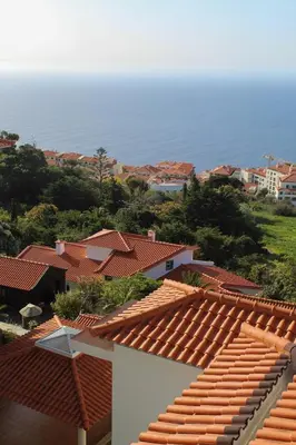 a view of the roofs of houses and the ocean at Charming Garajau by AH in Caniço