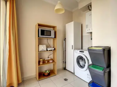 a laundry room with a washing machine and a microwave at Charming Garajau by AH in Caniço