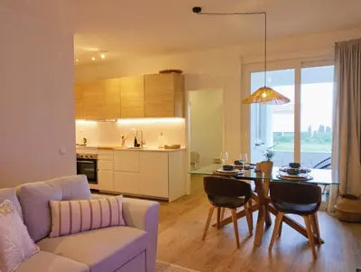 a living room and kitchen with a table and a couch at Bela Vista_ Cozy Apartment with Sea View in Aljezur