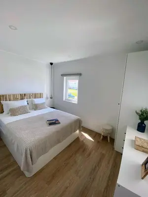 a white bedroom with a large bed and a window at Bela Vista_ Cozy Apartment with Sea View in Aljezur