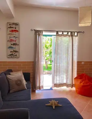 a bedroom with a bed with orange pillows at Casa Sagres in Vila do Bispo