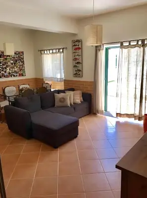 a living room with a couch and a glass table at Casa Sagres in Vila do Bispo