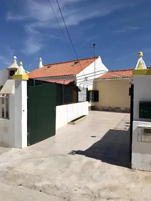 a green gate in front of a white building at Casa Sagres in Vila do Bispo