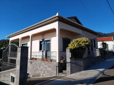 a white house with a fence in front of it at Casa do Vale da Estrela in Calheta