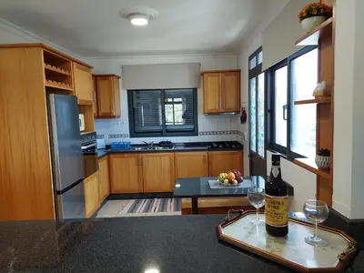 a kitchen with a bottle of wine and two glasses at Casa do Vale da Estrela in Calheta