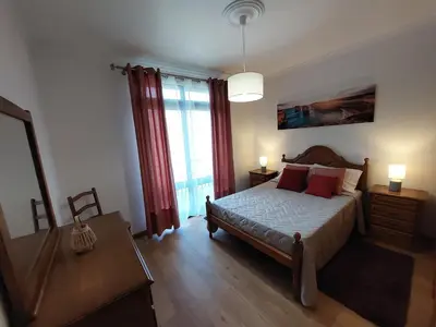 a bedroom with a bed and a large window at Casa do Vale da Estrela in Calheta