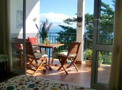 a room with a balcony with a table and chairs at Apartment Palma Madeira wandern und tauchen in Caniço