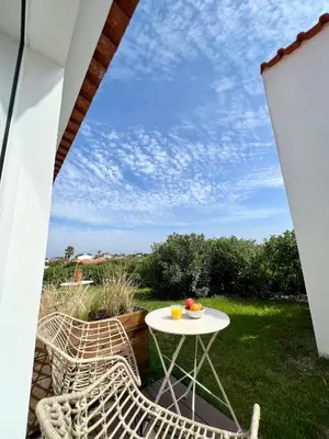 a table and chairs on a patio with a view at Sunday Morning Guesthouse in Aljezur