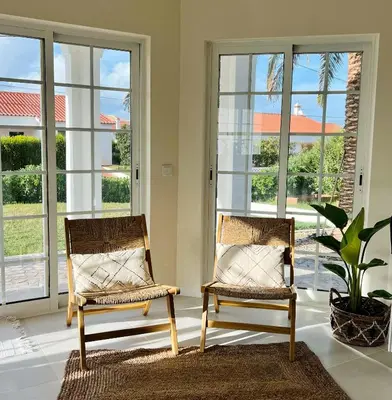 two chairs sitting in a room with windows at Sunday Morning Guesthouse in Aljezur