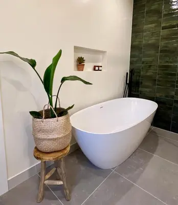 a bathroom with a white bath tub and a plant at Sunday Morning Guesthouse in Aljezur