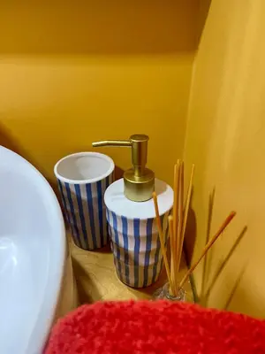 a corner of a bathroom with a toilet and two cups at Casa do mar in São Vicente