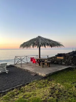 a table and chairs under a umbrella on the beach at Casa do mar in São Vicente