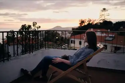 a woman sitting on a bench on a rooftop at Vila São Gonçalo in Funchal