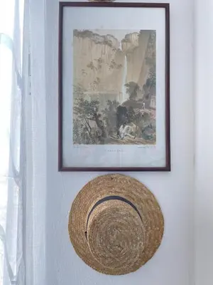 a picture hanging on a wall with a straw hat at Vila São Gonçalo in Funchal