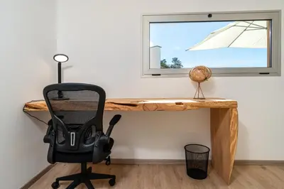 a desk with a chair in front of a window at Bella Vista (Heated Pool & Private Parking) in Arco da Calheta