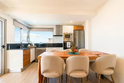 a kitchen with a wooden dining table and chairs at Bella Vista (Heated Pool & Private Parking) in Arco da Calheta