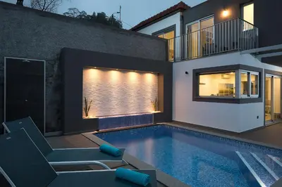 a house with a swimming pool in front of a house at Bella Vista (Heated Pool & Private Parking) in Arco da Calheta
