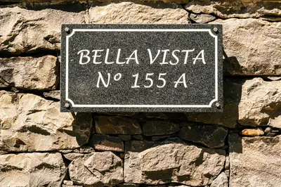 a sign on the side of a stone wall at Bella Vista (Heated Pool & Private Parking) in Arco da Calheta