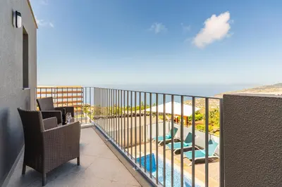 a balcony with chairs and a view of the ocean at Bella Vista (Heated Pool & Private Parking) in Arco da Calheta