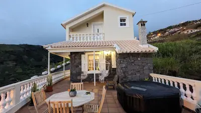 a house with a balcony with a table and chairs at Levada Nova House in Ponta do Sol